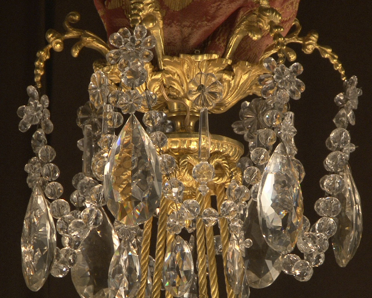 Lustre à cristaux à 12 bras et 18 lumières , décors de passementeries en bronze doré. Lustre à cristaux à 12 bras et 18 lumières , décors de passementeries en bronze doré.-3