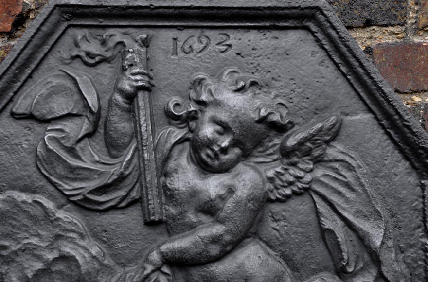 Plaque de cheminée ancienne datée 1693 au putto ailé tenant une torche Plaque de cheminée ancienne datée 1693 au putto ailé tenant une torche-1