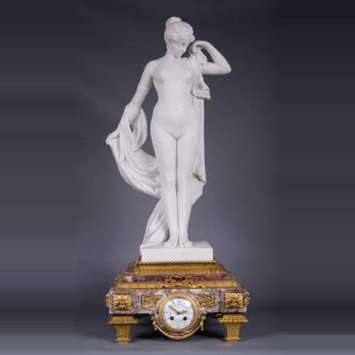 Pendule en marbre fleur de pêcher et bronze doré surmontée d’une sculpture en marbre   blanc statuaire représentant Phryné devant ses juges signée « Campagne », vers 1900