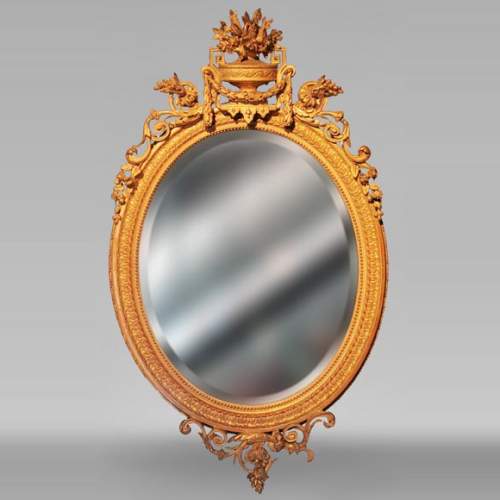 Miroir ovale en bois doré de style Louis XVI au vase fleuri