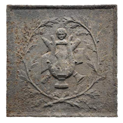 Plaque de cheminée ornée d’instruments de musique antiques entourés d’une couronne de laurier