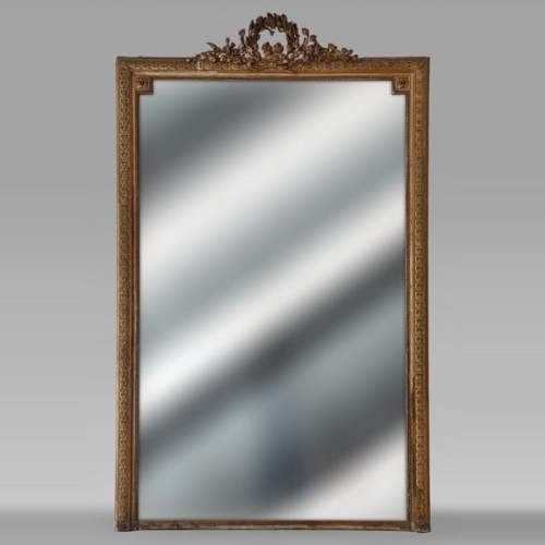 Trumeau doré de style Louis XVI orné d'une couronne de fleurs