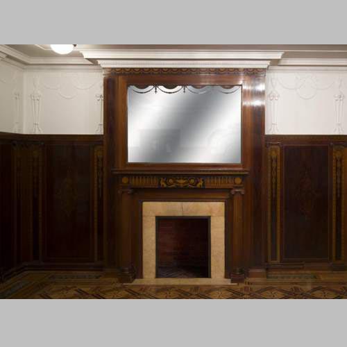 Exceptionnelle pièce de boiserie complète de style Regency en marqueterie d'acajou avec sa cheminée, France XIXè siècle