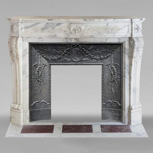 Cheminée de style Louis XVI galbée en marbre Arabescato décorée d'une couronne de laurier