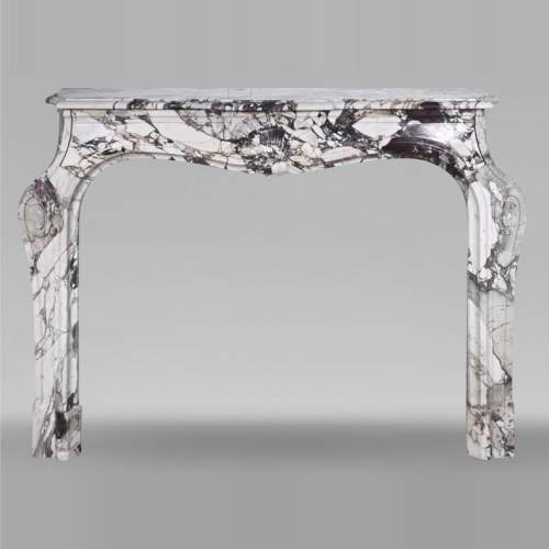 Cheminée de style Louis XV en brèche violette, décorée d'une coquille