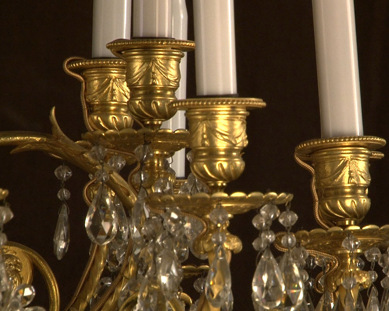 Lustre à cristaux à 12 bras et 18 lumières , décors de passementeries en bronze doré.-12