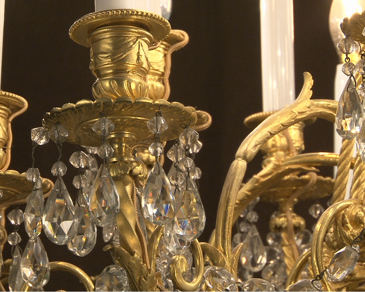 Lustre à cristaux à 12 bras et 18 lumières , décors de passementeries en bronze doré.-14