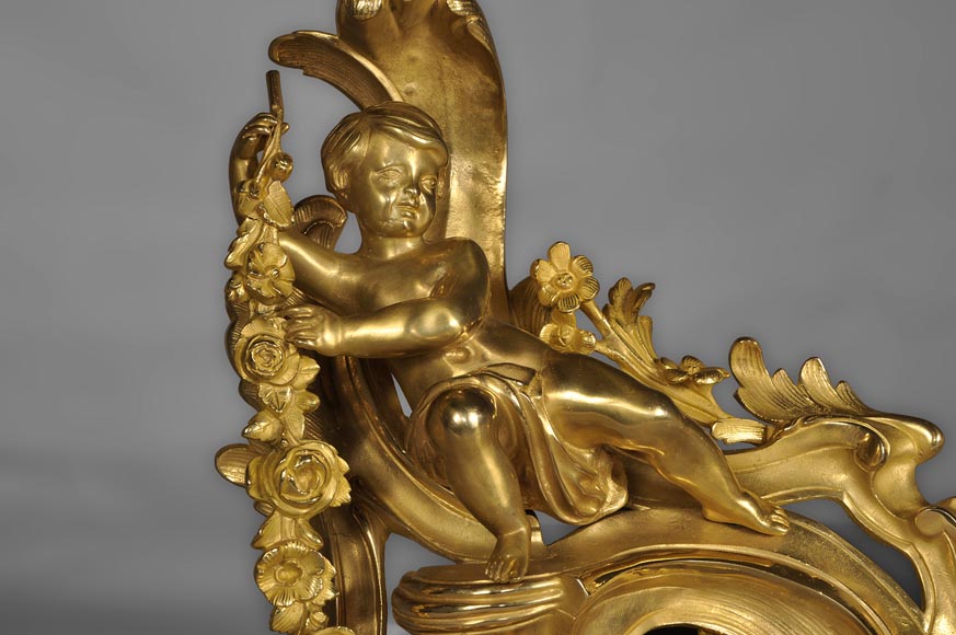 Paire de chenets ancien de style Louis XV en bronze doré à décor de putti-1