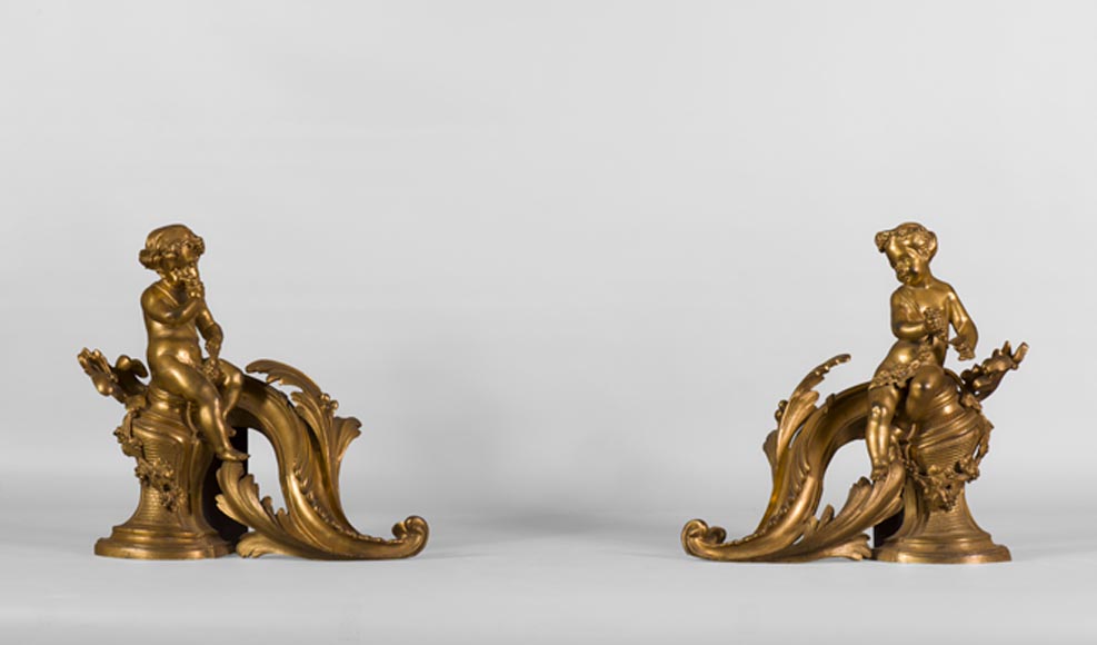 Paire de chenets de style Louis XV en bronze doré à décor d'enfants dans les vignes-0