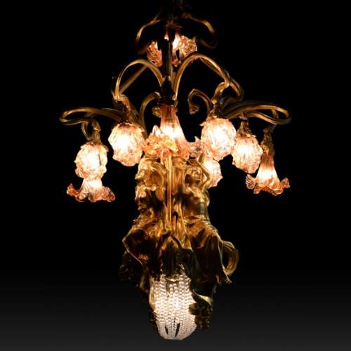 Beau lustre ancien de style Art Nouveau en bronze doré et verre moulé aux corps alanguis et aux neuf bras de lumière 
