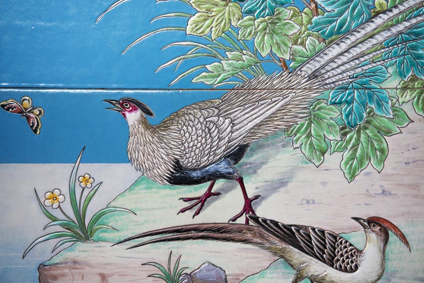 Paire de panneaux en céramique aux oiseaux dans un paysage lacustre signés 