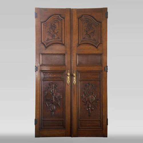 Double porte en chêne sculpté à décor de trophées militaires