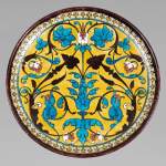 Théodore DECK (1823-1891) - Plat rond en céramique à décor oriental d'un vase fleuri et rinceaux feuillagés sur fond jaune
