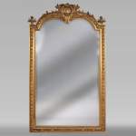 Trumeau ancien de style Napoléon III, en stuc doré et miroir biseauté