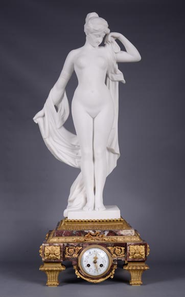 Pendule en marbre fleur de pêcher et bronze doré surmontée d’une sculpture en marbre   blanc statuaire représentant Phryné devant ses juges, signée « Campagne », vers 1900-0