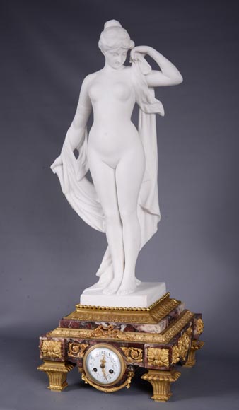 Pendule en marbre fleur de pêcher et bronze doré surmontée d’une sculpture en marbre   blanc statuaire représentant Phryné devant ses juges, signée « Campagne », vers 1900-2