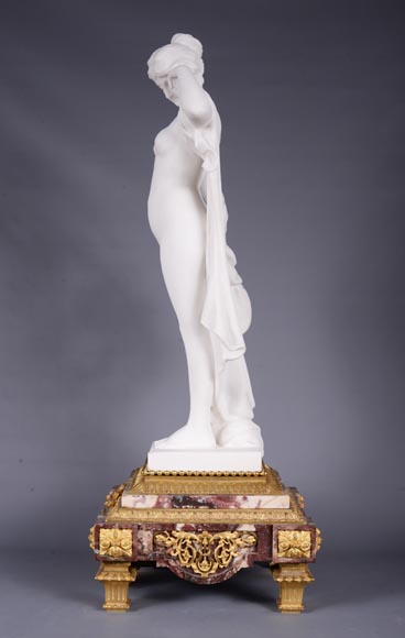 Pendule en marbre fleur de pêcher et bronze doré surmontée d’une sculpture en marbre   blanc statuaire représentant Phryné devant ses juges, signée « Campagne », vers 1900-3