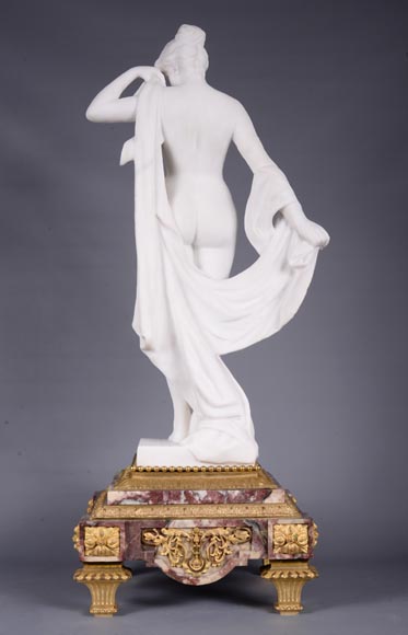 Pendule en marbre fleur de pêcher et bronze doré surmontée d’une sculpture en marbre   blanc statuaire représentant Phryné devant ses juges, signée « Campagne », vers 1900-4
