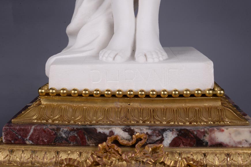 Pendule en marbre fleur de pêcher et bronze doré surmontée d’une sculpture en marbre   blanc statuaire représentant Phryné devant ses juges, signée « Campagne », vers 1900-8