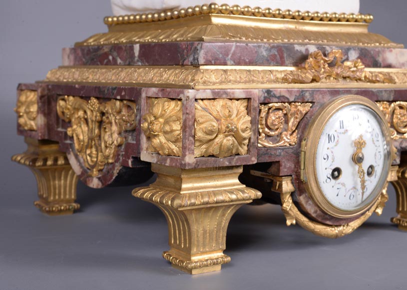 Pendule en marbre fleur de pêcher et bronze doré surmontée d’une sculpture en marbre   blanc statuaire représentant Phryné devant ses juges, signée « Campagne », vers 1900-10