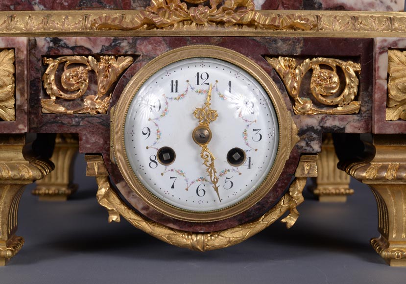Pendule en marbre fleur de pêcher et bronze doré surmontée d’une sculpture en marbre   blanc statuaire représentant Phryné devant ses juges, signée « Campagne », vers 1900-11