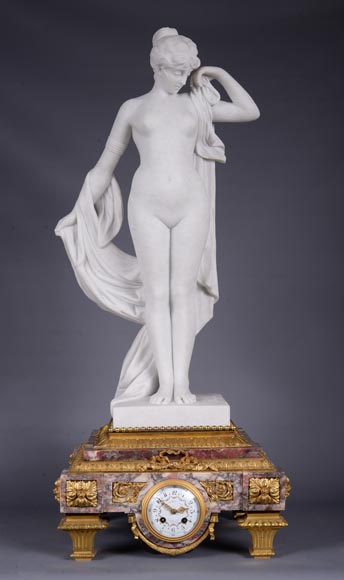 Pendule en marbre fleur de pêcher et bronze doré surmontée d’une sculpture en marbre   blanc statuaire représentant Phryné devant ses juges signée « Campagne », vers 1900-0