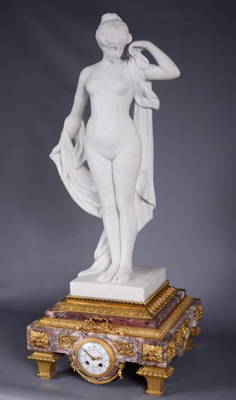 Pendule en marbre fleur de pêcher et bronze doré surmontée d’une sculpture en marbre   blanc statuaire représentant Phryné devant ses juges signée « Campagne », vers 1900-2