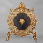 Pare étincelle en bronze doré de style Napoléon III aux mascarons de lion et de putto