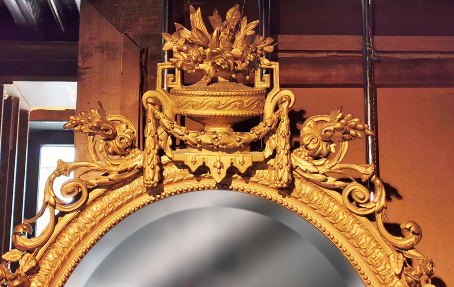 Miroir ovale en bois doré de style Louis XV au vase fleuri-1