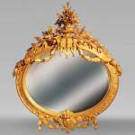 Miroir à l'abondant décor Louis XVI de guirlandes et rameaux