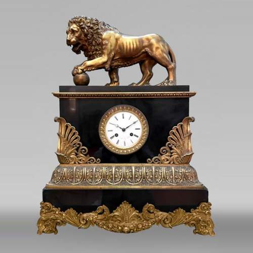Pendule au lion de style Empire en marbre noir et bronze doré