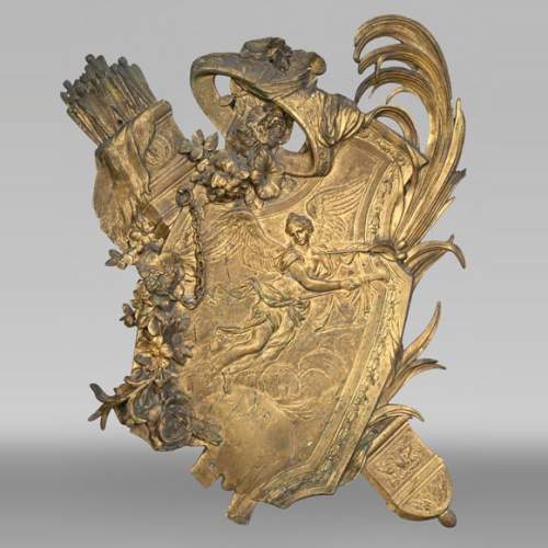 Union Centrale des Arts Décoratifs, plaque décorative en bronze doré en forme de bouclier, à la Victoire ailée et trophées d'armes