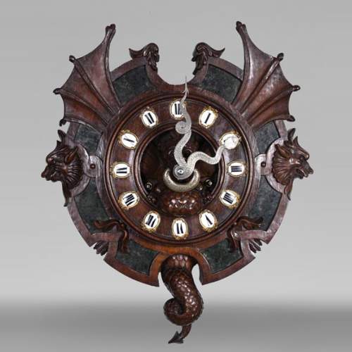 Pendule XIXe en noyer sculpté à décor de chimères, plaques d’agate mousseuse, bronze argenté, émail.