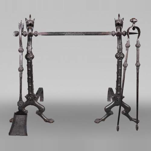 E. LARCHEVÊQUE, paire de chenets et accessoires en fer forgé à têtes de dragons