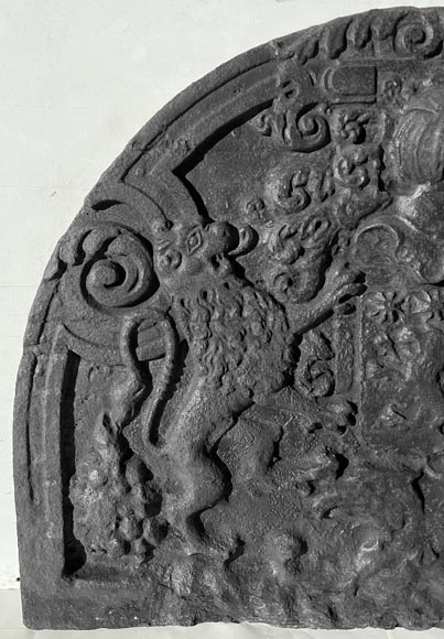 Plaque de cheminée en demi cercle en fonte, décorée d'armoirie, surmontée d'un heaume et encadrée de lions-1
