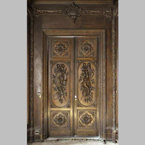 Grande pièce de boiserie ancienne en chêne sculpté à décor de trophées de chasse et natures mortes