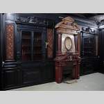 Rare pièce de boiserie Napoléon III en bois noirci avec sa cheminée monumentale en stuc à l'imitation du porphyre