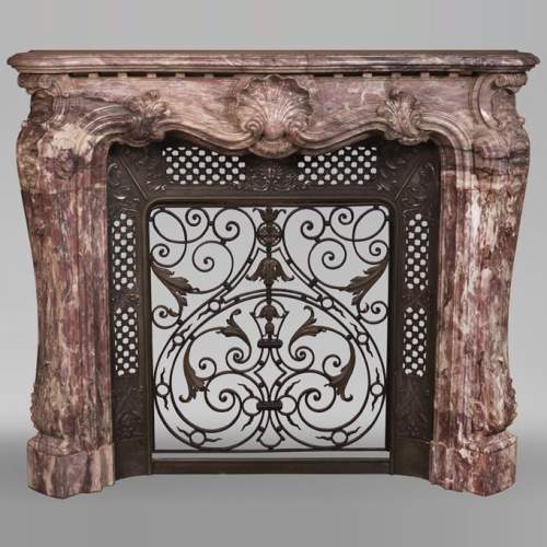 Très belle cheminée ancienne de style Louis XV en marbre Fleur de Pêcher richement sculptée