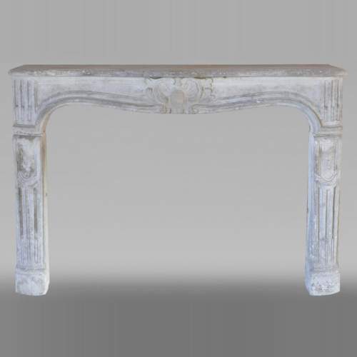 Cheminée d'époque Louis XV en pierre sculptée d'une coquille finement sculptée.