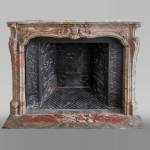 Cheminée ancienne de style Louis XV richement ornée en marbre Sarrancolin