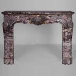 Importante cheminée de style Louis XV ornée d'une feuillette, réalisé en marbre Fleur de Pêcher