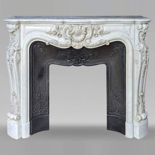 Cheminée de style Louis XV au décors fleuri sculpté en marbre de Carrare