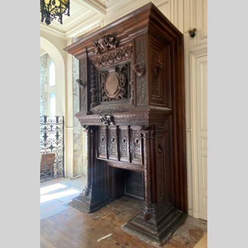 Importante cheminée de style Néo Renaissance sculptée en bois de noyer et de chêne