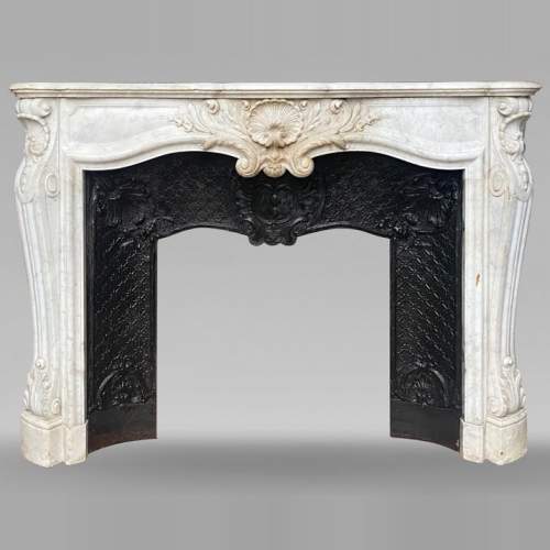 Cheminée de style Louis XV avec coquille encadrée de palmettes sculptée en marbre de Carrare