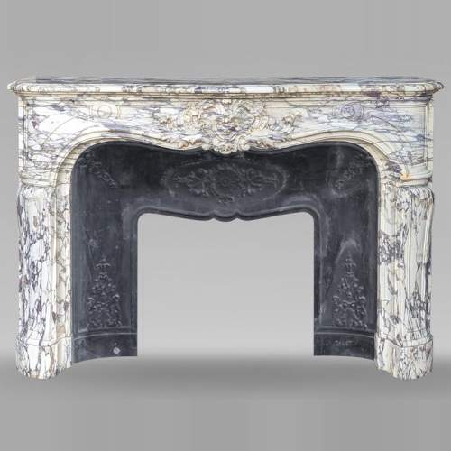 Importante cheminée de style Régence richement sculptée en marbre brèche violette