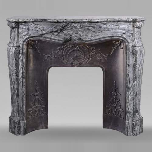 Cheminée de style Louis XV ornée d'une coquille sculptée en marbre Bleu Fleury