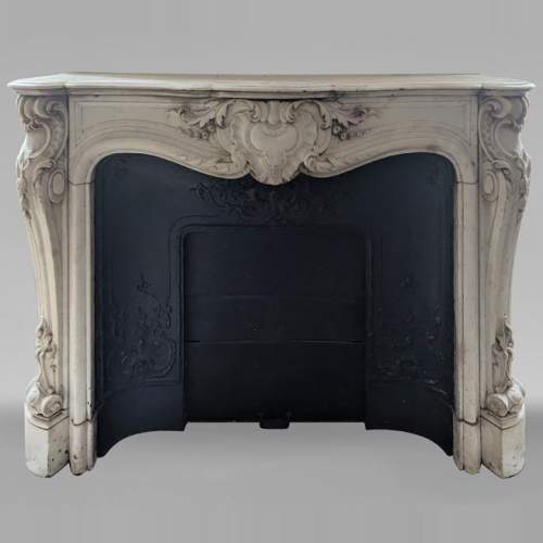Cheminée de style Louis XV en marbre de Carrare richement sculptée d'un décor végétal