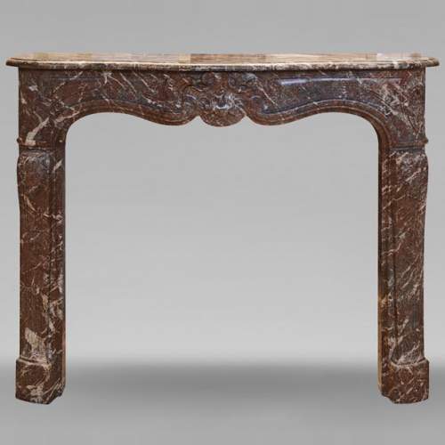 Cheminée de style Louis XV en marbre Rouge Royal décorée d'une coquille asymétrique