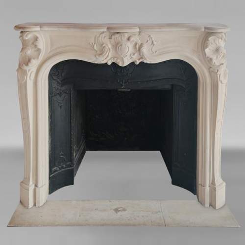 Cheminée de style Louis XV en pierre décorée d'une coquille asymétrique