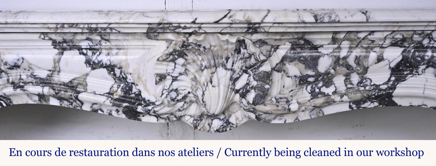 Cheminée de style Régence en brèche violette, décorée d'une grosse coquille-1